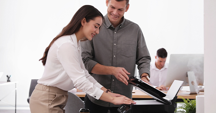 People standing around a printer.