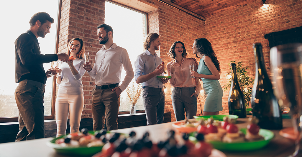 Group of people celebrating next to a buffet.
