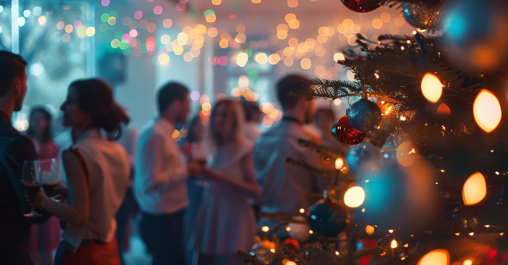 Christmas tree with a blurred background of partygoers in party attire.