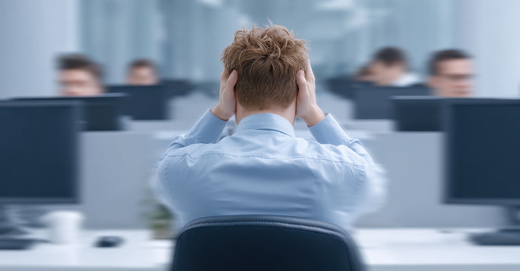 Distressed office worker holding head against blurred background